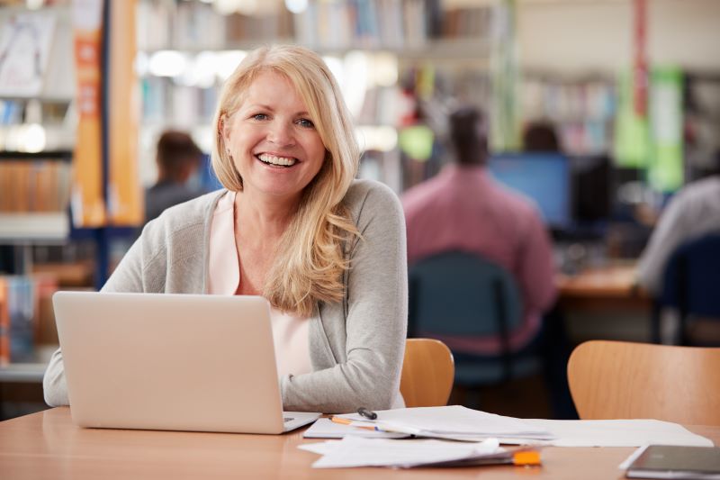 A portrait of an education graduate student studying at a library table.