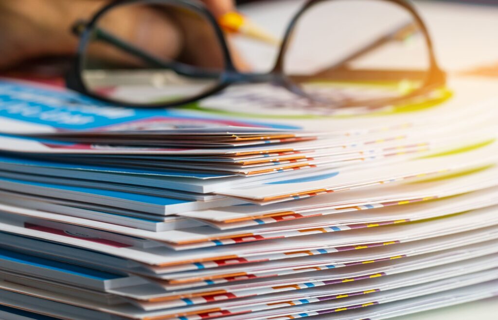 A stack of report papers lays in an organized pile.