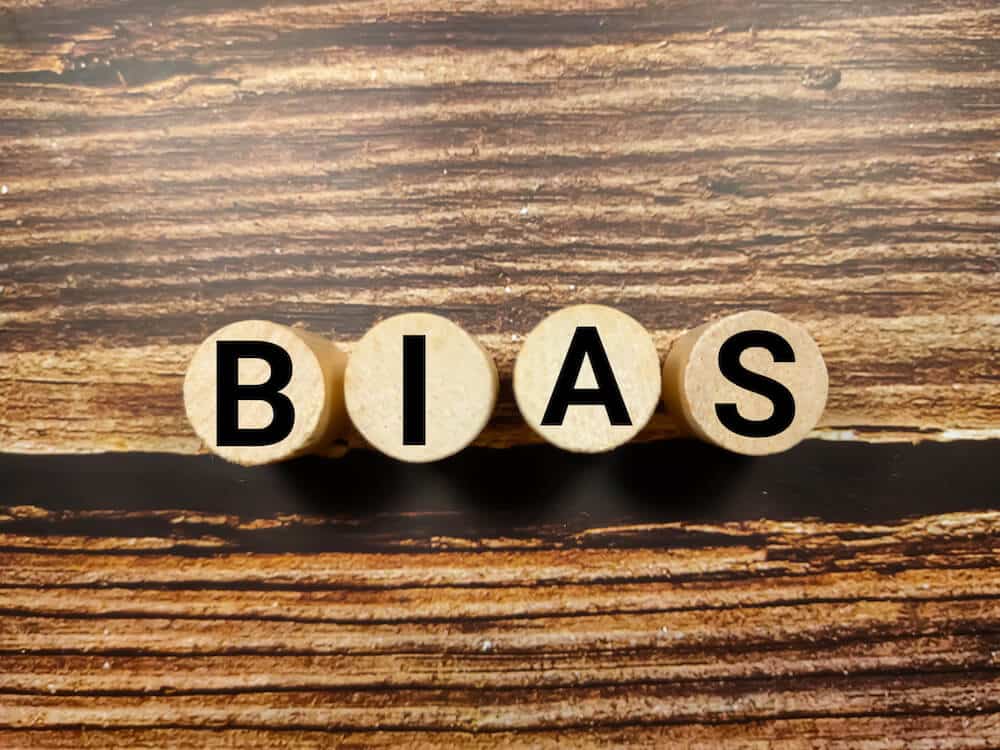 ‘BIAS’ spelled out on wooden cylinders in a table.