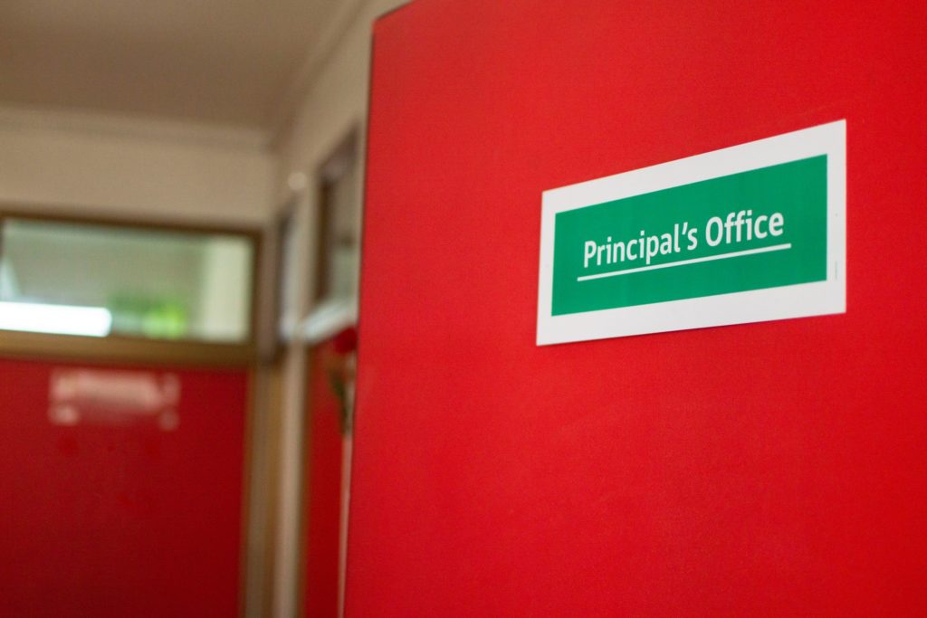 Wall with sign that reads principal's office