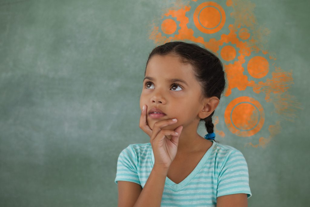 A thoughtful young girl thinks, spray painted gears on the wall behind her head to symbolize complex thinking.