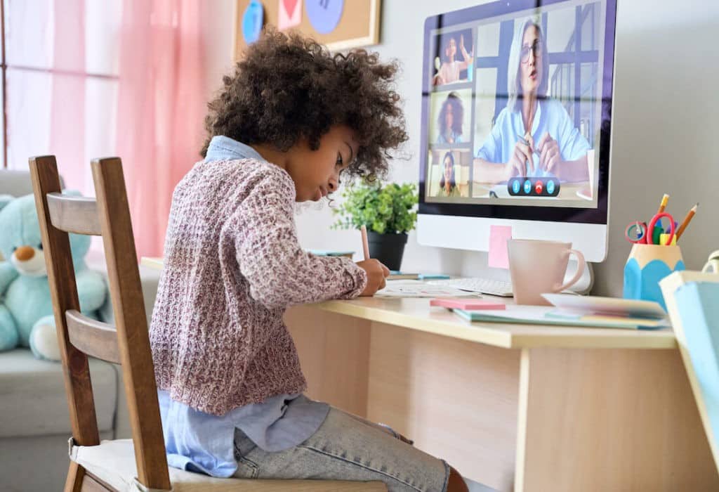 A young girl working at her desk during virtual learning