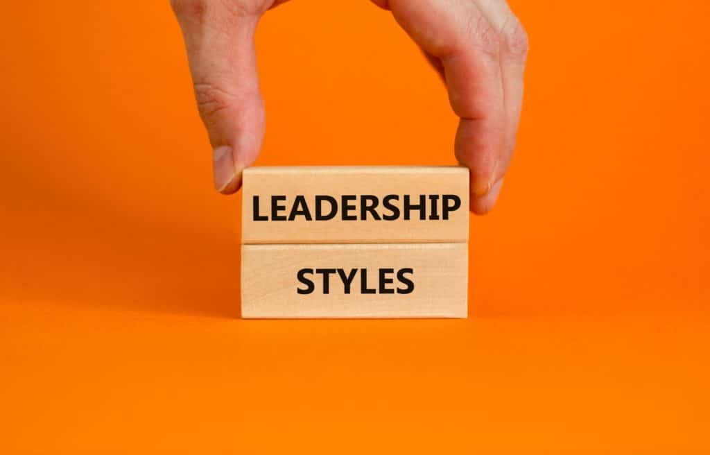 Someone stacks wooden blocks with the words “leadership styles” printed on them.
