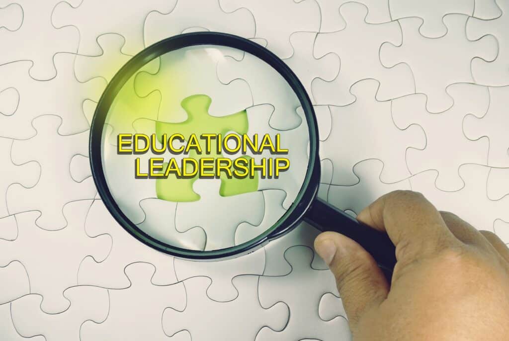 A magnifying glass magnifies a puzzle that says “educational leadership.”