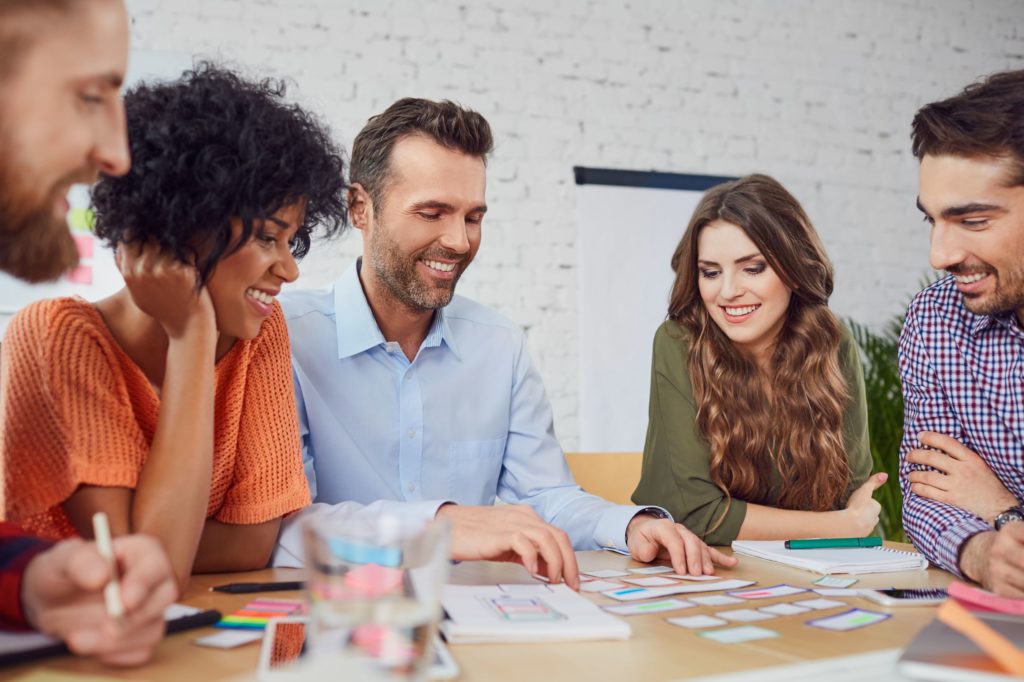 Group of adults sitting together at a table working on a project.