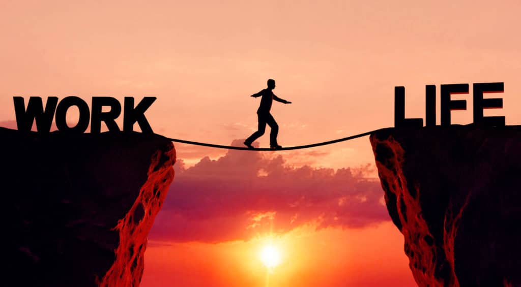 Man walking across a board between two cliffs: work and life