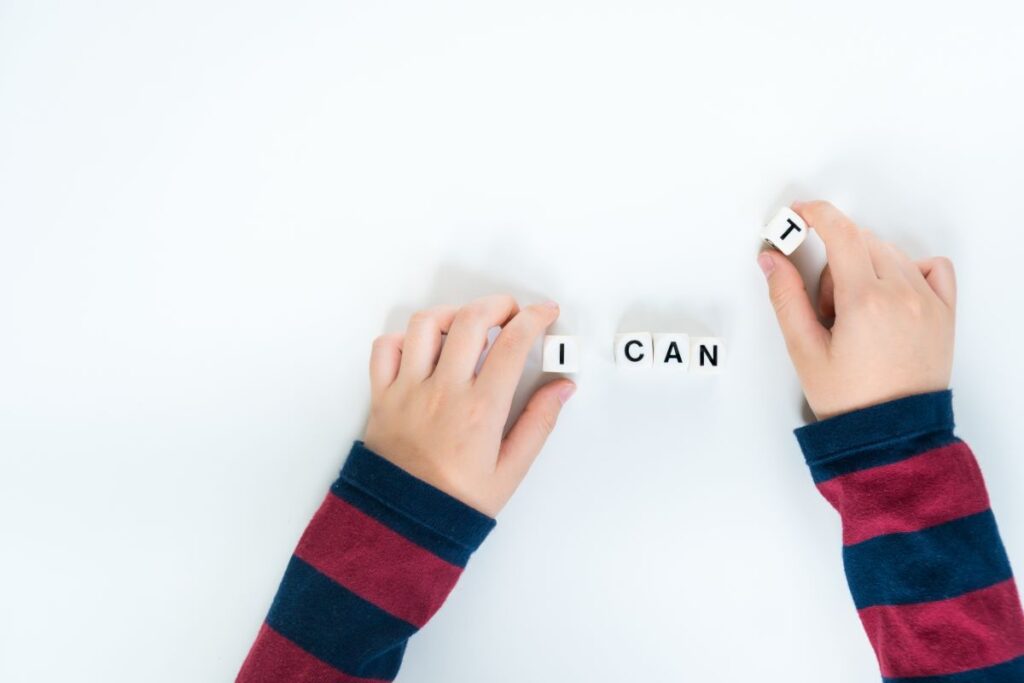 A young child changes letter blocks from saying, “I can’t” to “I can," representing student-self esteem.