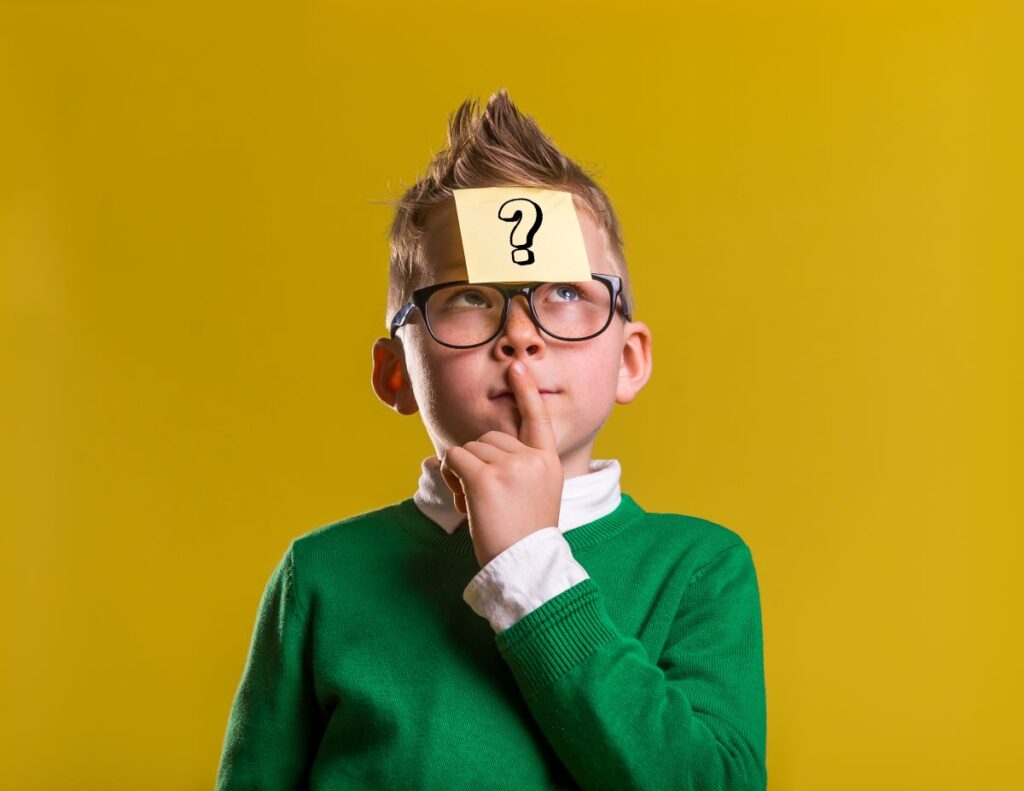 A portrait of a student thinking with a question mark Post-It note on his forehead.