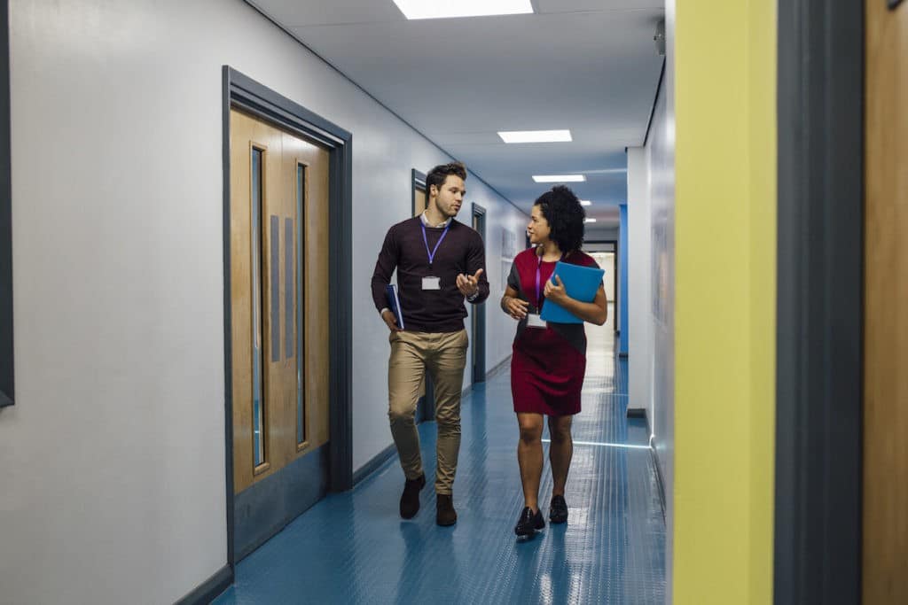 Two administrators walking down the hall talking